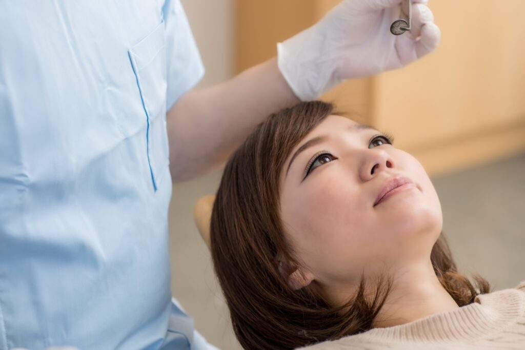 歯科治療中、治療椅子にて天井の業務エアコンを眺めている患者