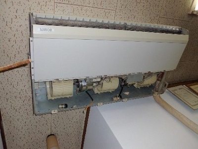 居酒屋店舗に使用されていた、汚れた天吊り型エアコンを完全に分解作業中の画像