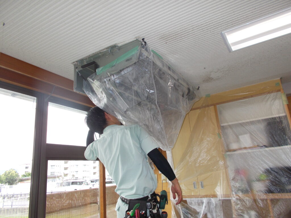 業務用エアコンを完全分解し、点検作業している