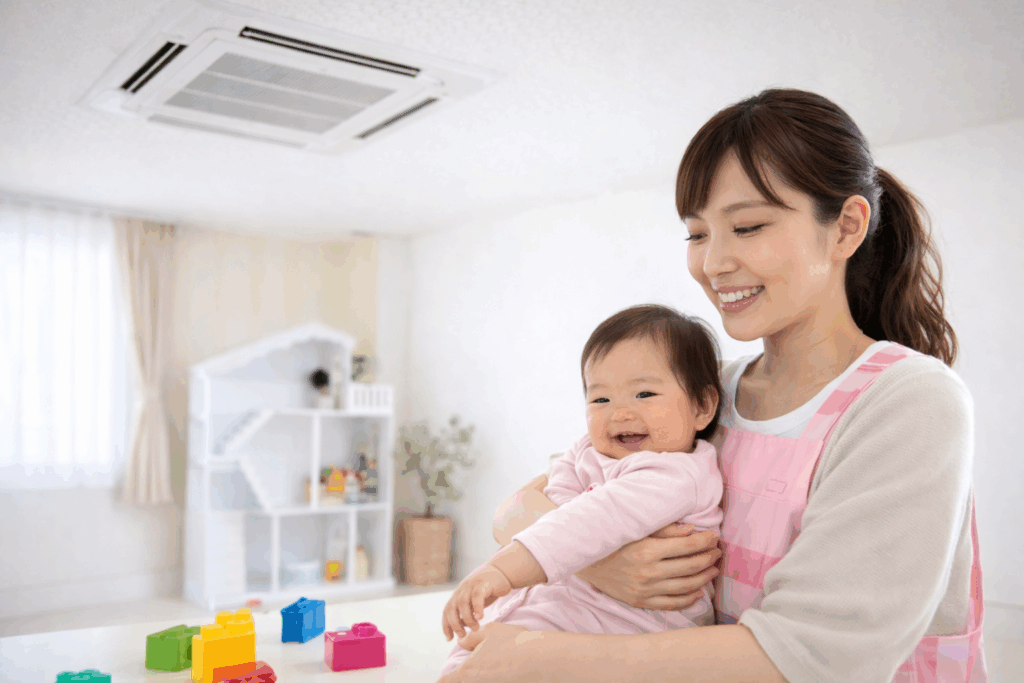 エアコンクリーニング後にすずしく快適な保育園の教室で笑顔の保育士と子ども