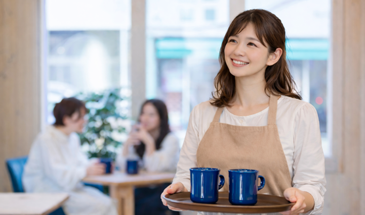 業務用エアコン改善後の快適な店内で接客する女性スタッフ