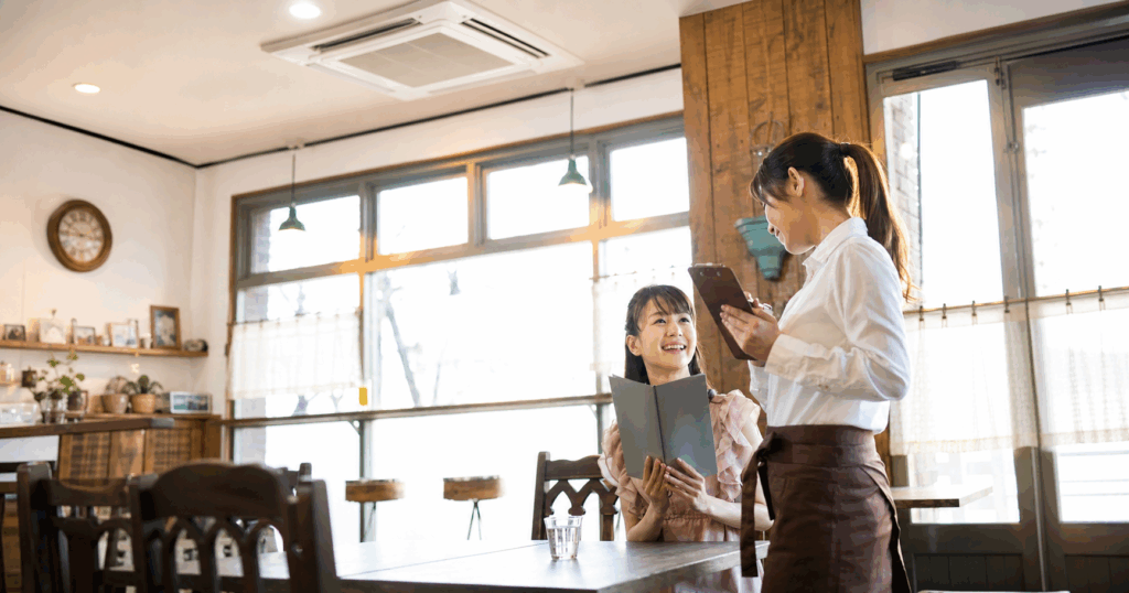 福岡市の飲食店 女性オーナーと来店客 店内の天井カセットエアコンと快適な空間の様子