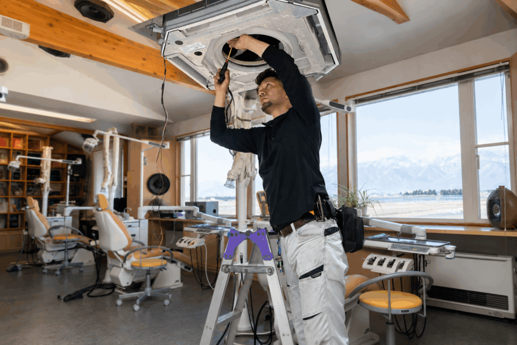歯科医院で天井カセット型業務用エアコンを点検している作業風景