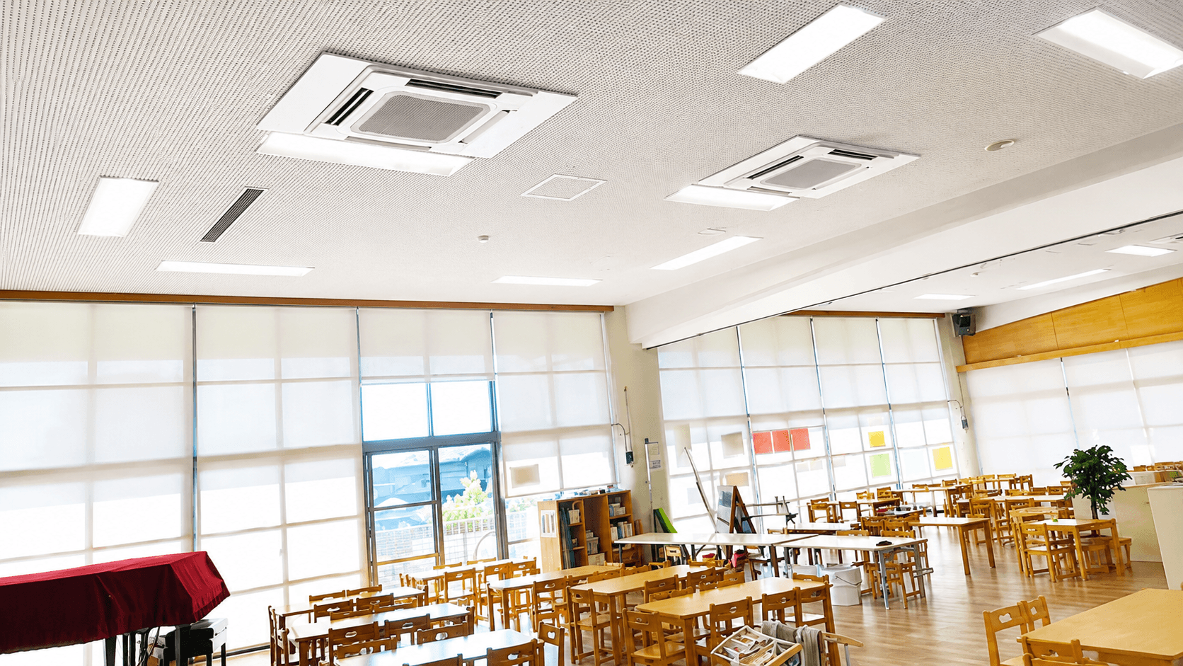 幼稚園講堂の天井に設置された高所業務用エアコン