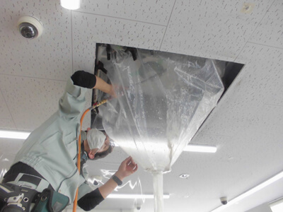 福岡市で天井カセット形業務用エアコンに洗浄する作業員